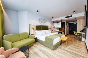 um quarto de hotel com uma cama e um sofá em Barceló Budapest em Budapeste