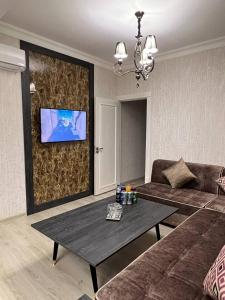 una sala de estar con un sofá y una mesa en Orient INN Apartment, en Tashkent