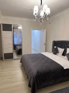 Un dormitorio con una cama grande y un espejo grande. en Orient INN Apartment, en Tashkent