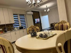 a kitchen with a table with chairs and a dining room at Orient INN Apartment in Tashkent
