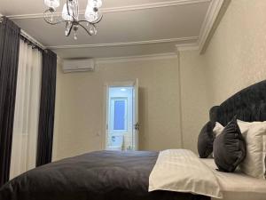 a bedroom with a bed and a chandelier at Orient INN Apartment in Tashkent