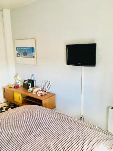 1 dormitorio con 1 cama y TV en la pared en Les hauteurs de la Capelette en Marsella
