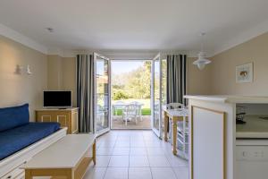 a living room with a couch and a kitchen with a table at Maison pour 6 - Piscine - Port Bourgenay in Talmont-Saint-Hilaire