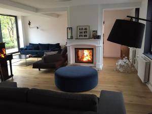 sala de estar con sofá y chimenea en Ferme rénovée 300M2 La Casa JEB : Charme, Calme et Nature en Moncheaux