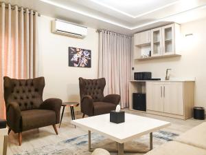 uma sala de estar com duas cadeiras e uma mesa em Musada Luxury Hotels and Suites em Abuja