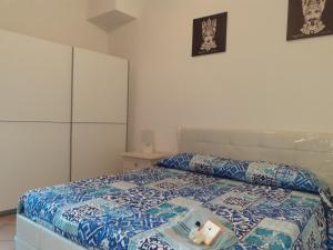 sypialnia z łóżkiem z niebiesko-białą kołdrą w obiekcie Castel Tauro Apartment w Taominie