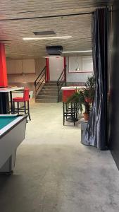 an empty room with a pool table and tables at L'Excess Hotel in Vierzon