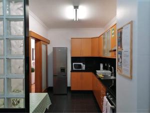 uma cozinha com armários de madeira e um frigorífico de aço inoxidável em Plaza Charming Flat em Santa Cruz
