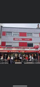 a hotel with tables and chairs in front of a building at L'Excess Hotel in Vierzon