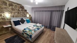 a bedroom with a bed and a stone wall at Alqueiturismo - Casas de Campo in Guarda +84 photos