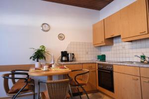a kitchen with a table with chairs and a stove at Ferienwohnungen Berger in Kötschach