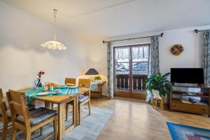 a dining room and living room with a table and chairs at Ferienwohnung Lechner in Farchant