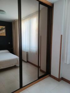 lustro w sypialni z łóżkiem i pokoju z łóżkiem w obiekcie Apartamentos Playa de Portio w mieście Liencres