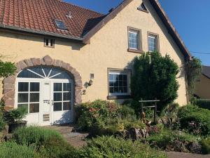 a house with a white door and some flowers at Vintage Apartment Hase 