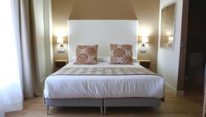 a bedroom with a large bed with two pillows at Añoreta Suites in Rincón de la Victoria