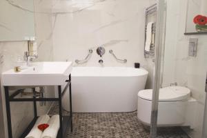 a bathroom with a tub and a toilet and a sink at Castlecourt Hotel, Spa & Leisure in Westport