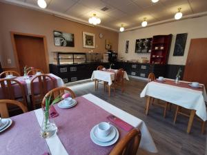 a dining room with tables and chairs and a kitchen at Hotel Mainperle in Wertheim