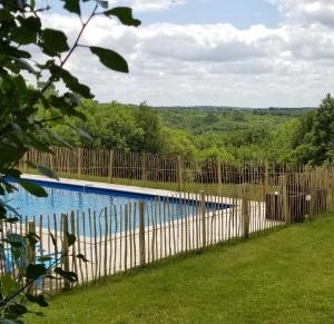 a fence next to a swimming pool with a view at Gites de Ponsillou in Lavercantière