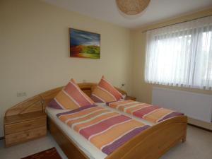 a bed with striped pillows in a bedroom at Ferienwohnung Neumann in Gersfeld