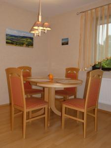 uma sala de jantar com uma mesa de madeira e cadeiras em Ferienwohnung Neumann em Gersfeld