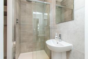 a bathroom with a shower with a sink and a toilet at Coldharbour Suites in Bristol