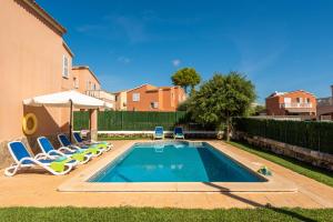 a swimming pool with lounge chairs and an umbrella at Villa Llevant in Cala en Blanes