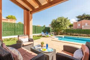 a patio with chairs and a swimming pool at Villa Llevant by Escape Home in Cala en Blanes