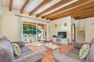 a living room with two couches and a tv at Villa Llevant in Cala en Blanes