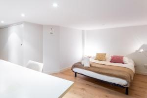 Habitación blanca con cama y silla en DIFY Drevet - Bellecour, en Lyon