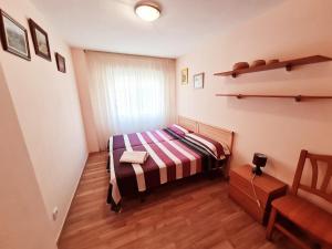 a small bedroom with a bed and a chair at Apartamento Aqua in La Pineda +33 photos
