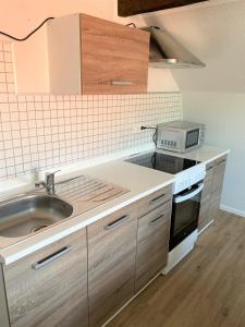 a kitchen with a sink and a microwave at P8 Ferienwohnung in Remscheid