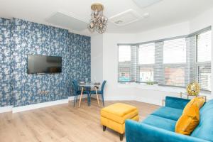 a living room with a blue couch and a table at Coldharbour Suites in Bristol