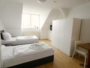 Un dormitorio con dos camas y un escritorio y una mesa. en SUNNYHOME Monteurwohnungen und Apartments in Erfurt, en Erfurt
