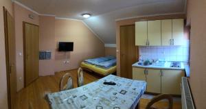 een kleine kamer met een tafel en een keuken met een bed bij Apartmani Turalija in Kupres
