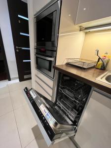 an open dishwasher in a kitchen with a sink at Budapest Downtown in Style - Luxury Apartment in Budapest
