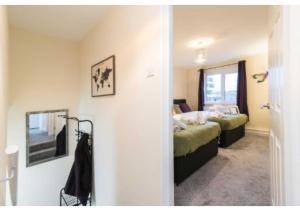 - une chambre avec 2 lits et un miroir dans l'établissement Sublime Stays Coventry- Jenner Pet Friendly Apartment with Parking, à Coventry