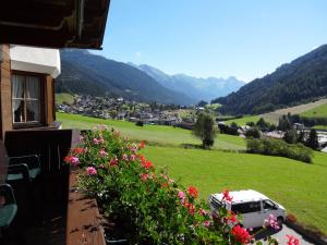 a house with a car parked in a field of flowers at Landhaus Strolz in Sankt Anton am Arlberg