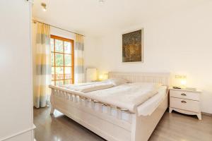 a white bedroom with a large bed and a window at Ferienwohnung Anna in Reit