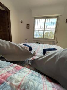 1 dormitorio con 2 camas con almohadas y ventana en Habitaciones en casa rural particular La Casita, en Ibi