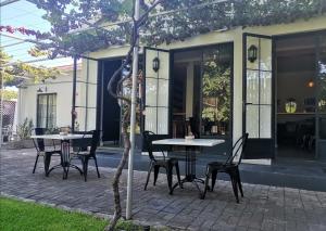 a patio with tables and chairs next to a building at Beautiful Betty B&B in Beaufort West