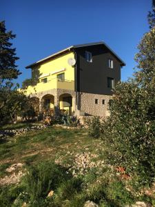 a house on top of a hill with a yard at APARTMENT ŽUŽI Otok Silba Hrvatska in Silba