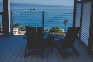 a table and chairs on a deck with a view of the ocean at Flying Flags Avila Beach in Avila Beach