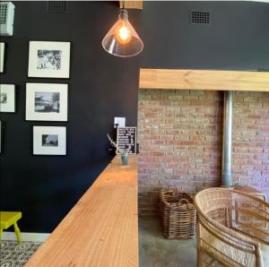 a dining room with a table and a brick wall at Beautiful Betty B&B in Beaufort West