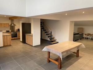 cocina y sala de estar con mesa y escalera en Magnifique corps de ferme rénové avec Jacuzzi, en Hillion