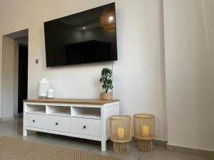 a living room with a white cabinet and two stools at APARTMENT SAUNA INFRARED in Szczecin