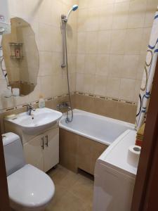 uma casa de banho com um lavatório, uma banheira e um WC. em Cozy apartments on Lushpy Avenue em Sumy