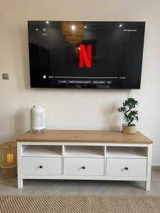 a white entertainment center with a tv on a wall at APARTMENT SAUNA INFRARED in Szczecin