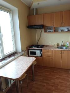 uma pequena cozinha com uma mesa e um lavatório em Cozy apartments on Lushpy Avenue em Sumy