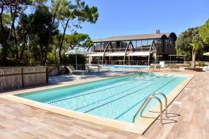 a large swimming pool with a building in the background at Canado Club Family Village in Marina di Castagneto Carducci