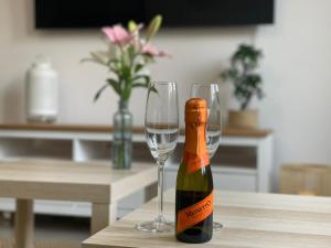 a bottle of champagne and two glasses on a table at APARTMENT SAUNA INFRARED in Szczecin +32 photos